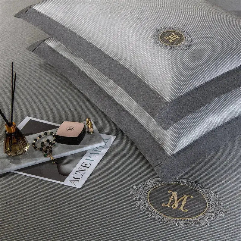Gray striped pillowcases with gold embroidered monogram m on the front from silver carbon light cooling mat bed sheet set