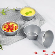 Set of three silver carbon steel mini round cake molds by decorbites with yellow custard garnished with mint and pomegranate seeds