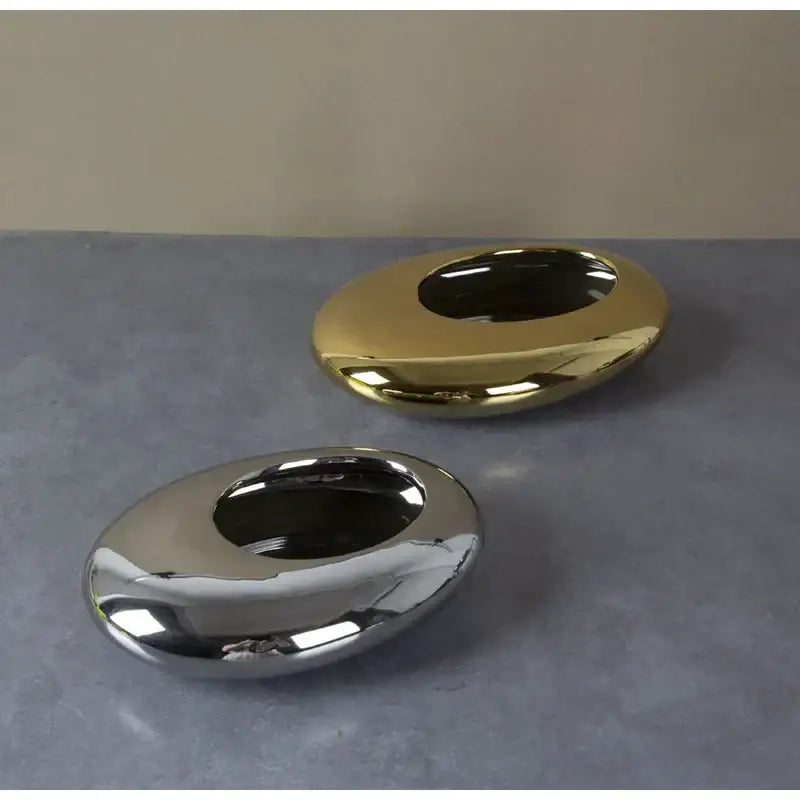 Shiny silver and gold metallic oval ashtrays complementing decorbites silver cobblestone ceramic vase and bowl decor