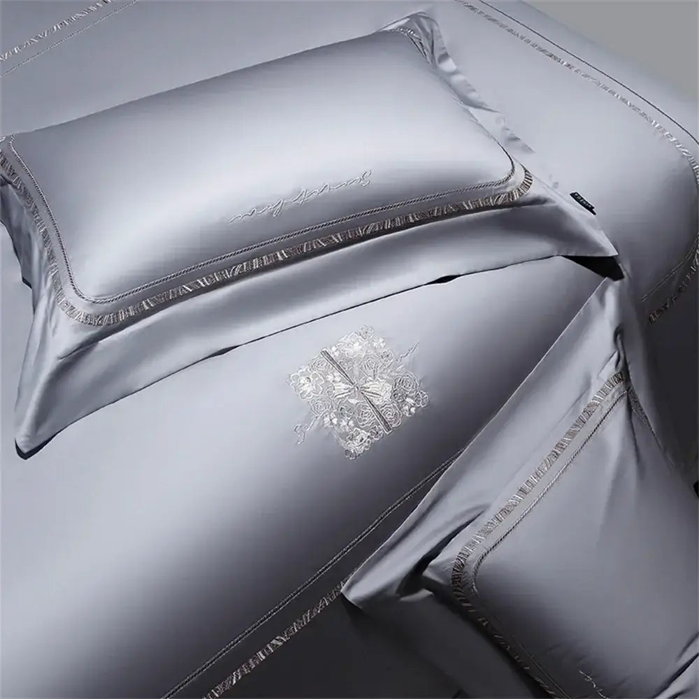 Silver cotton satin jacquard pillowcases with delicate embroidered floral patterns and matching trim in bedding set