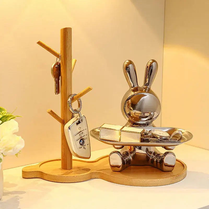 Shiny silver decorbites astronaut rabbit resin tray with metallic finish seated on wooden base for office storage