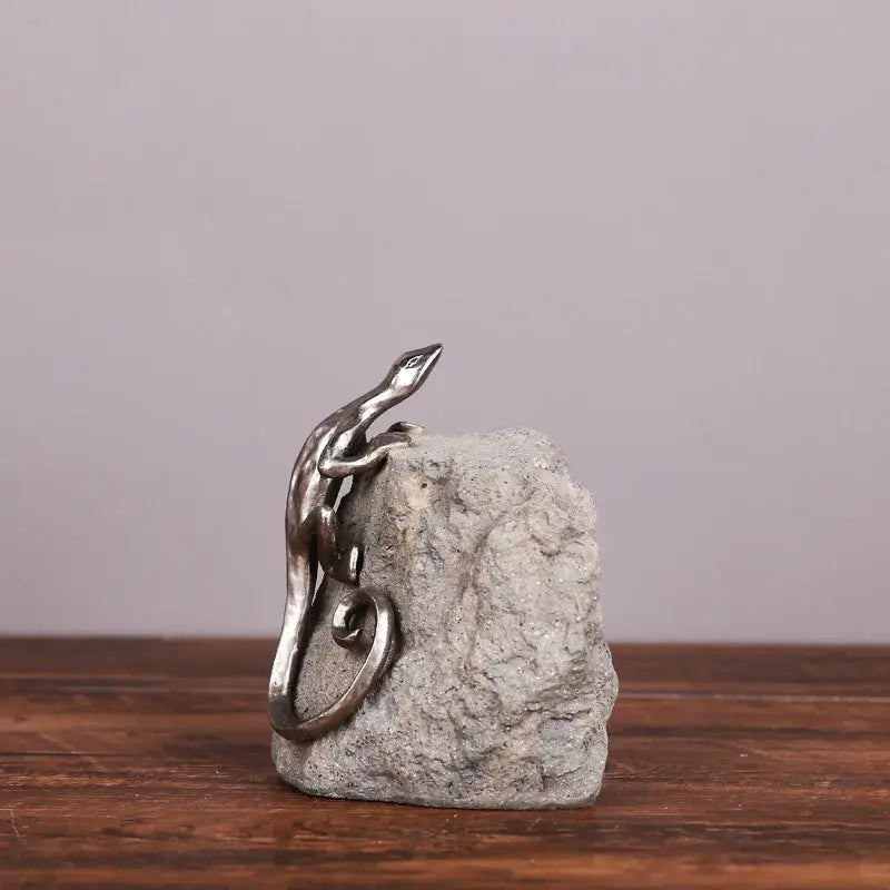 Silver metallic gecko lizard resin figurine perched on textured gray stone base for living room decorbites decor