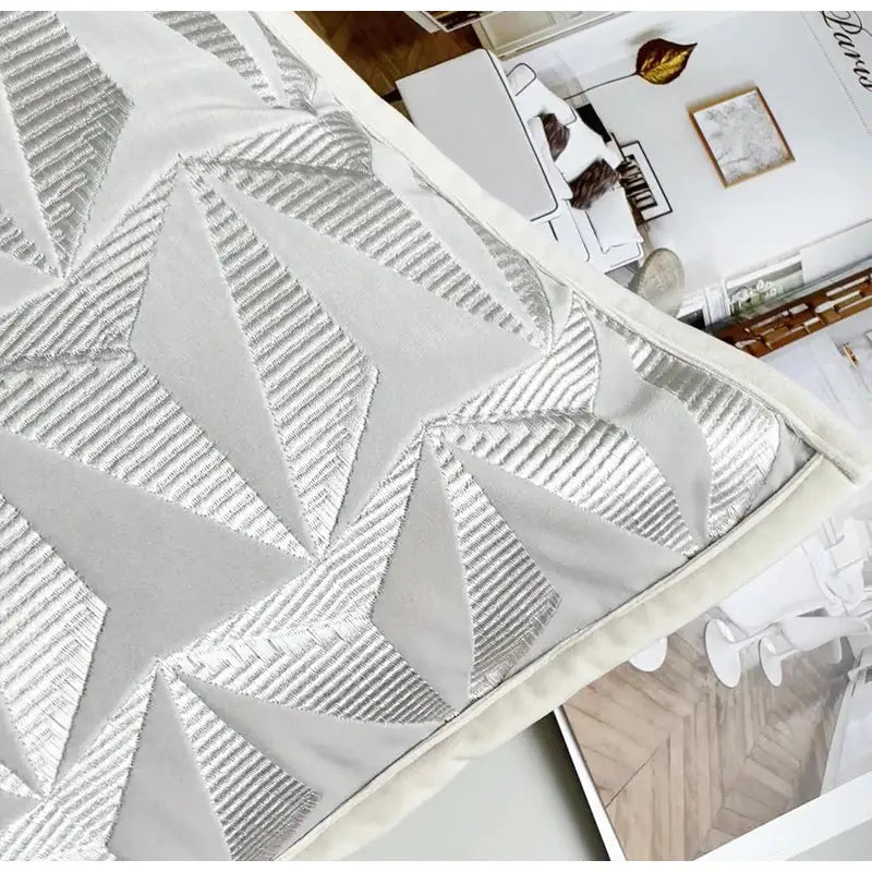Silver geometric embroidery pillow cover with textured stitched star shapes and cream border for luxe living room decorbites conical geometric
