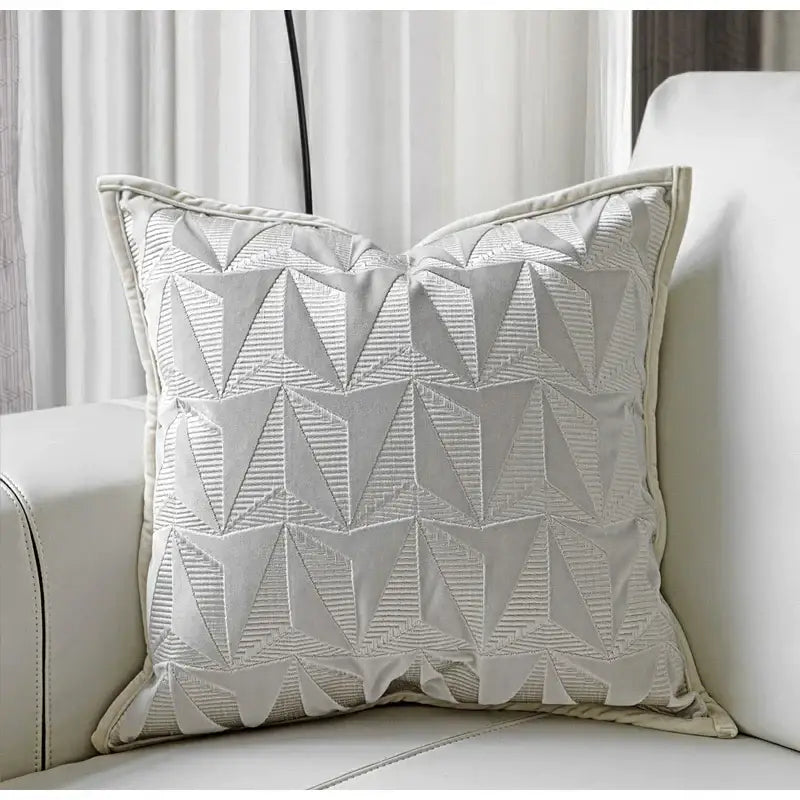 Off-white pillow cover with silver geometric embroidery and textured stitched triangles for luxe living room decorbites conical geometric design