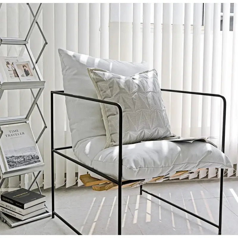 Modern black metal frame armchair with light gray cushions and silver geometric embroidery pillow cover decorbites conical geometric
