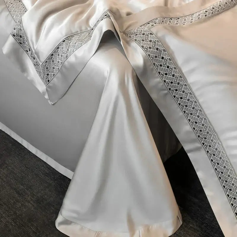 Cream-colored satin bedsheet with black and silver geometric embroidery in a decorbites eucalyptus fiber summer quilt set