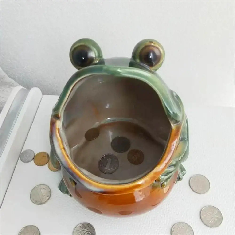 Glossy green and orange ceramic frog sculpture storage box with wide open mouth holding coins for living room decor storage box