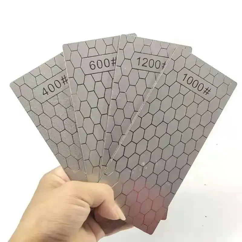 Silver-colored abrasive sanding sheets with hexagonal grid and numbered grit levels for diamond knife sharpener set