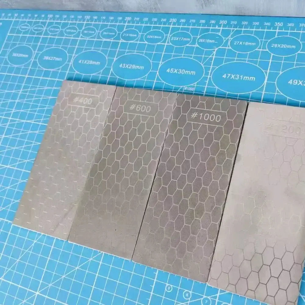 Four silver rectangular metal diamond knife sharpener sheets with hexagonal grit in a knife sharpener set