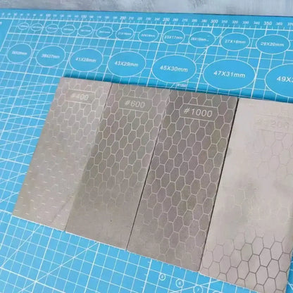 Four silver rectangular metal diamond knife sharpener sheets with hexagonal grit in a knife sharpener set