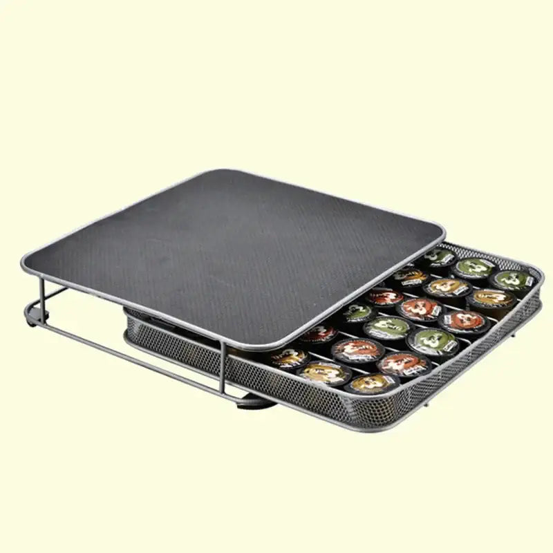 Silver metal coffee capsule storage rack with black textured lid and mesh tray holding multiple k-cup pods decorbites coffee capsule