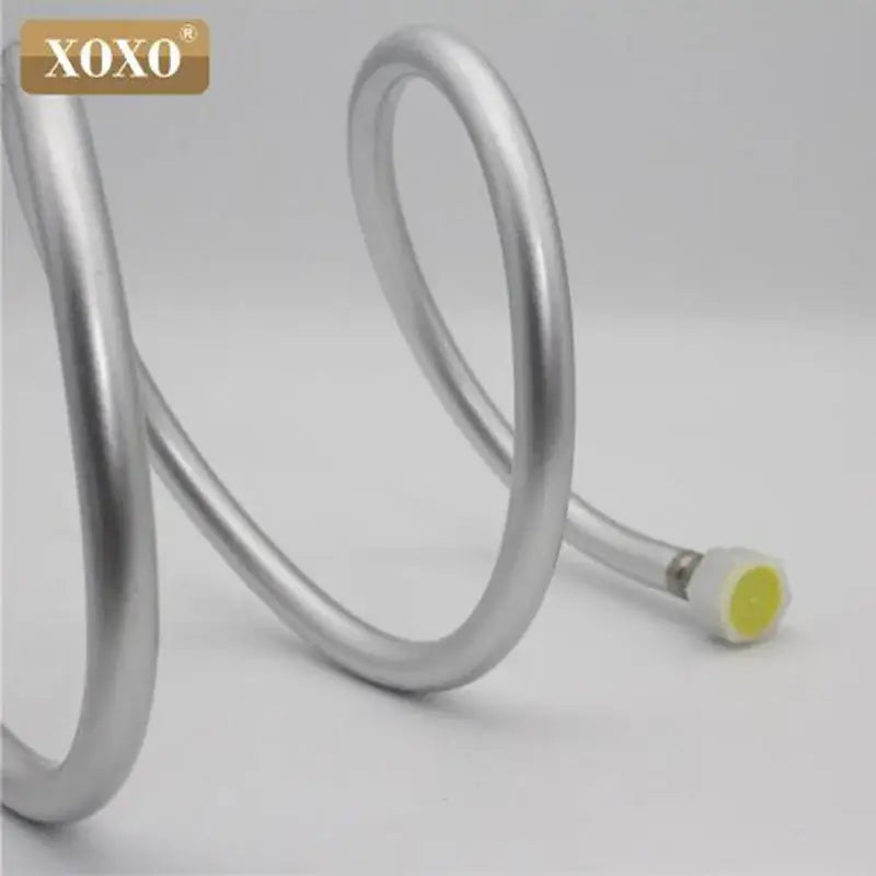 Silver pvc flexible shower hose with metallic spiral design and yellow-tipped connector branded xoxo for bathroom use