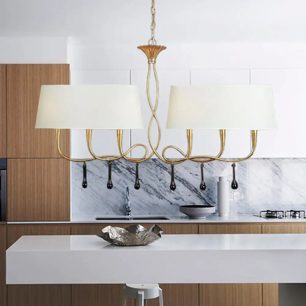 Gold-toned chandelier with cream fabric shades and black teardrop pendants for dining room lighting