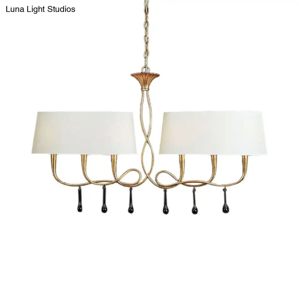 Gold-toned dining room chandelier with two white fabric shades and black teardrop pendants for elegant lighting