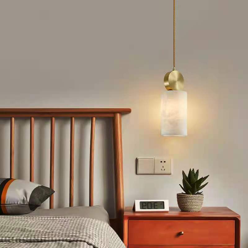 Brass and frosted glass pendant light with a modern design.