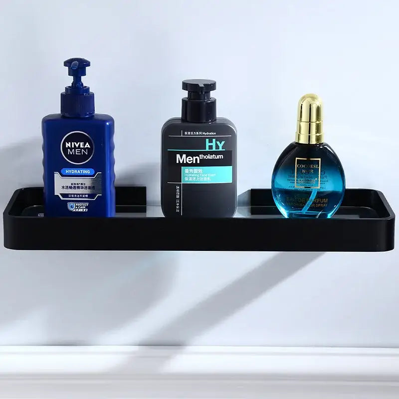 Black aluminum glass shelf for bathroom storage by decorbites holding three grooming products on sleek rectangular rack