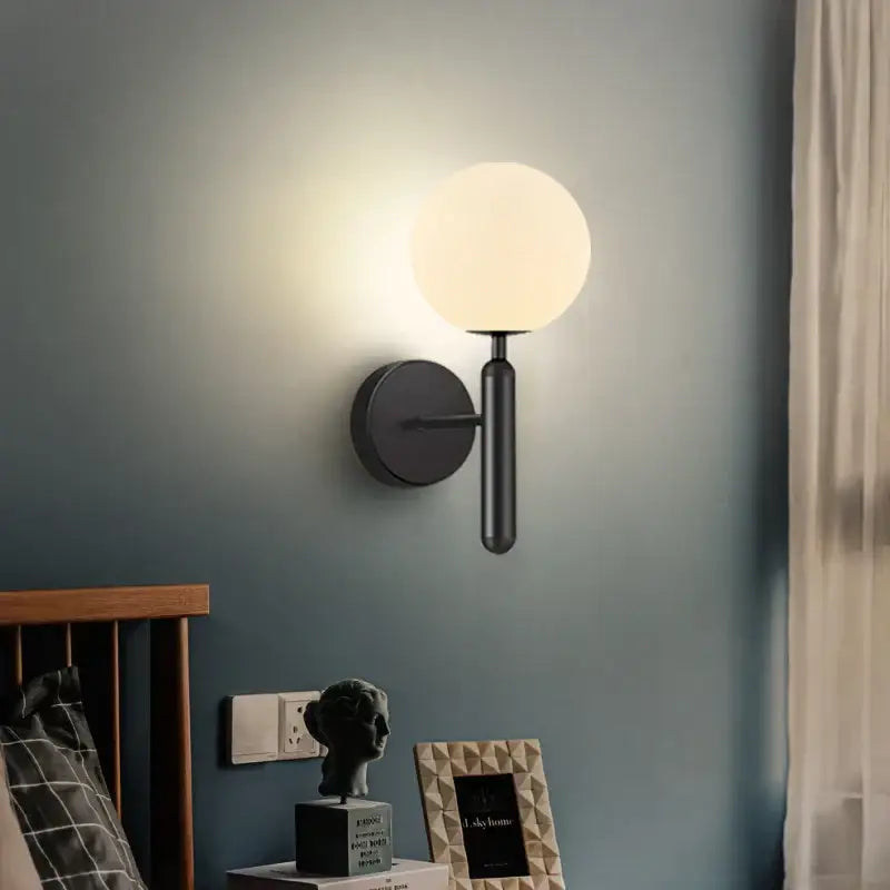 Black matte wall sconce lamp with frosted glass sphere perfect for sleek corridor lighting