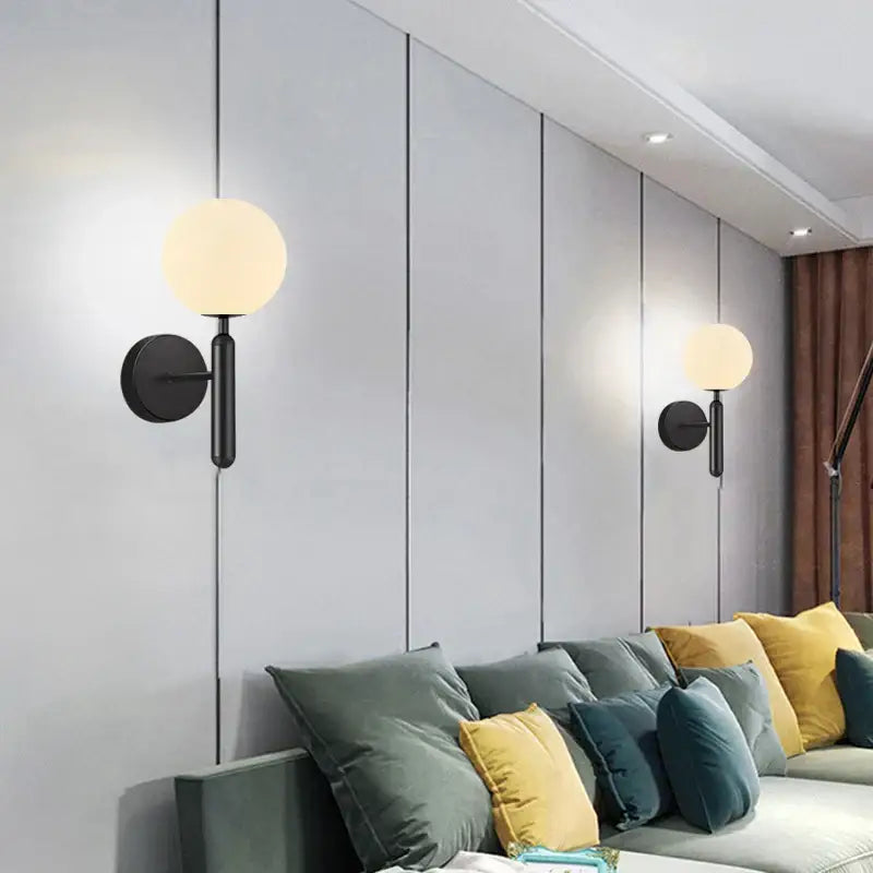Black wall sconce lamp with warm frosted glass globe and brass glass sphere design for corridor lighting