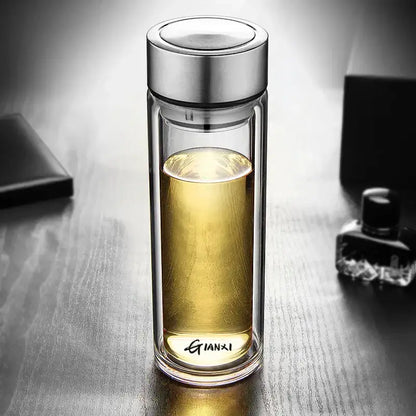 Sleek double-walled glass water bottle with silver lid and base engraved gianxi filled with golden liquid