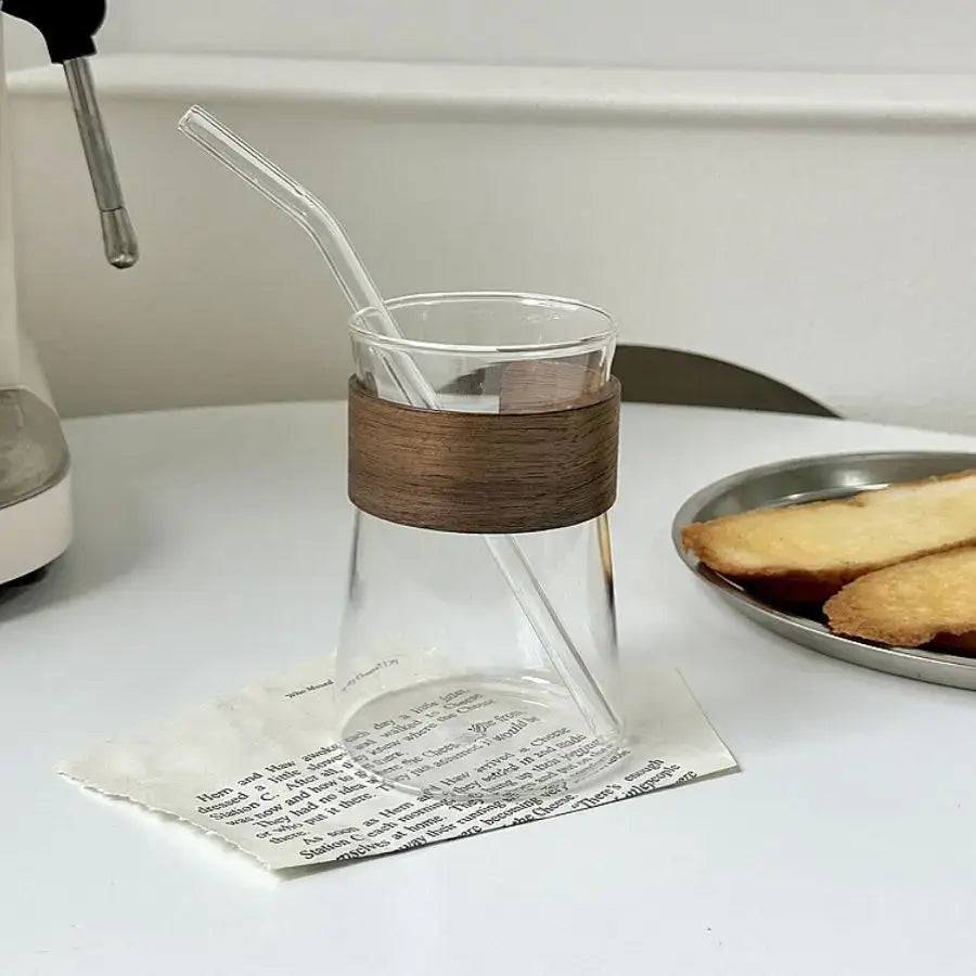 Sleek clear glass iced latte coffee cup with dark wood band and clear straw for decorbites glass iced drink use