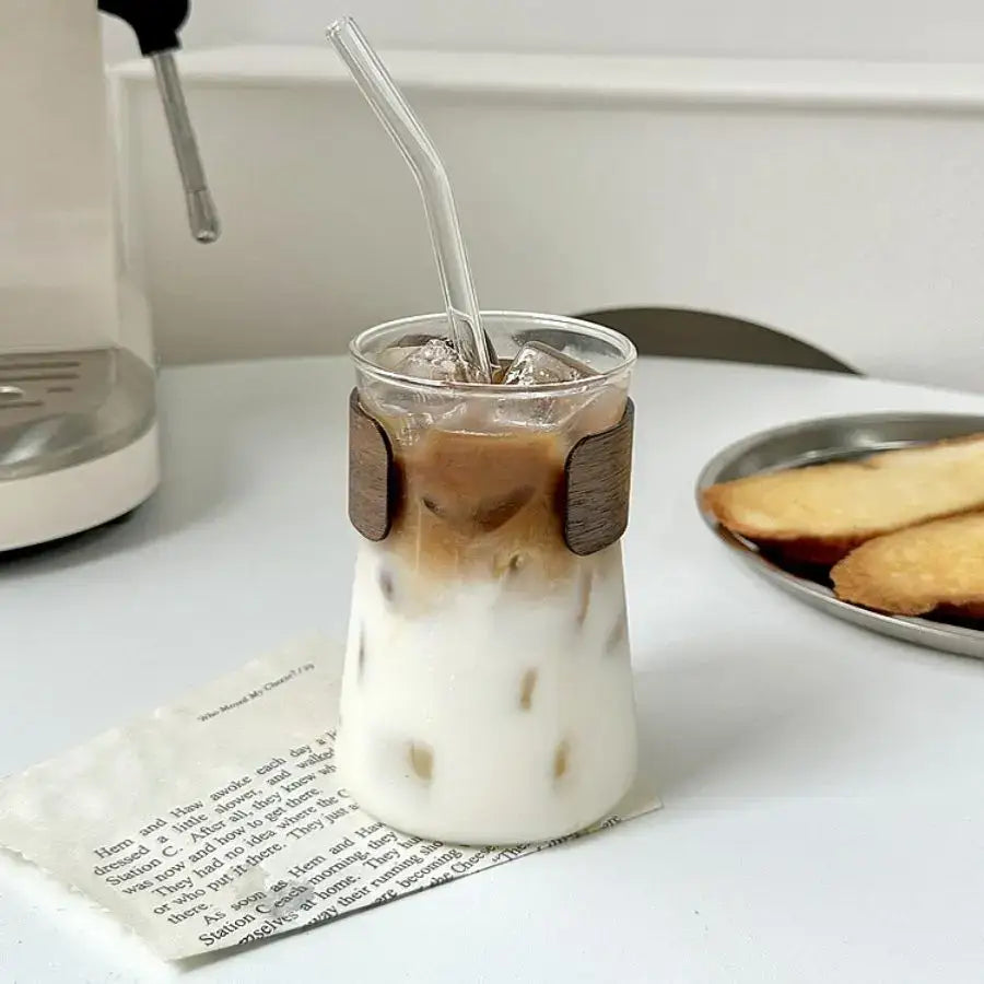 A clear glass iced latte tumbler with wooden wrap filled with iced latte coffee for stylish decorbites glass iced use