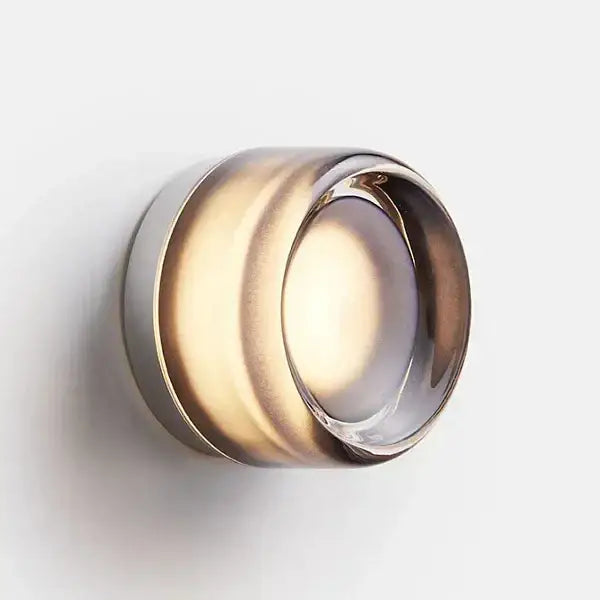 Sleek gold round wall sconce with translucent amber glass body and polished metallic rim for bathroom use