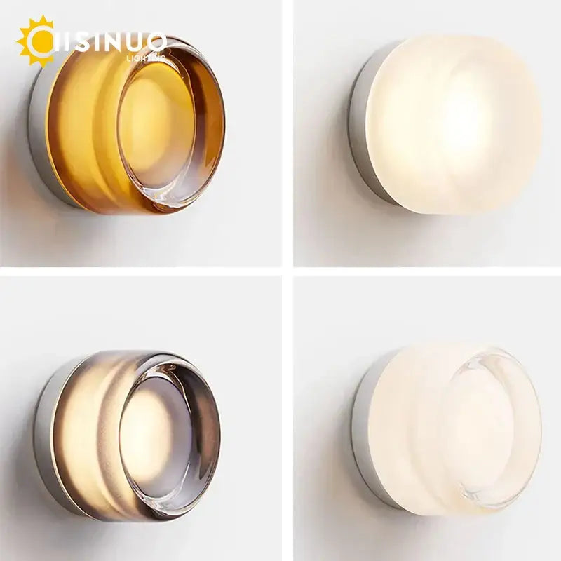 Sleek gold round wall sconce with frosted glass diffuser and metallic base available in amber warm white and clear finishes