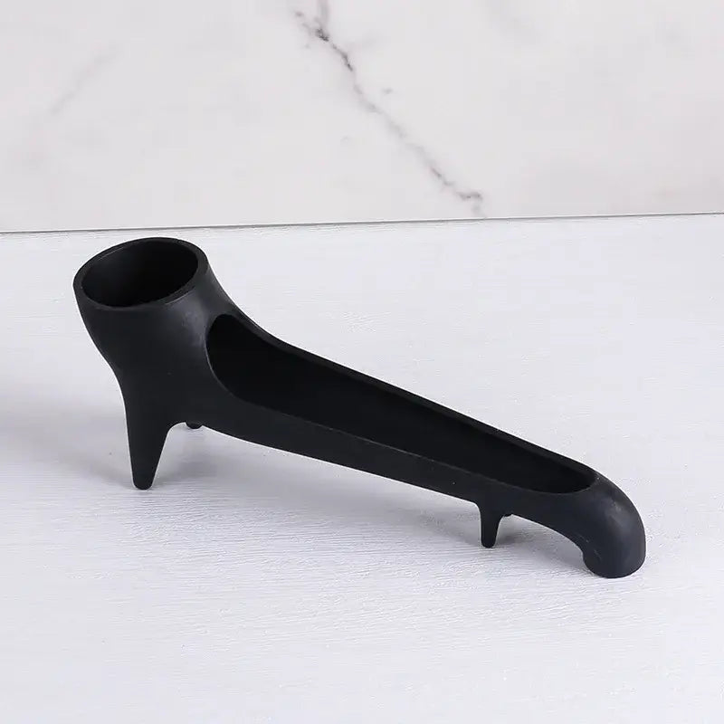 Black matte ceramic ashtray with three pointed feet and handle shown alongside sleek gray silicone water tank deflector