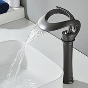 Sleek matte black brass basin faucet with waterfall design and sculptural form by decorbites for bathroom use