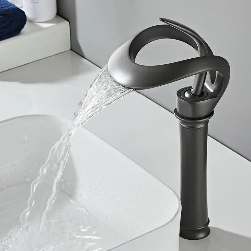 Sleek matte black brass basin faucet with waterfall design and sculptural form by decorbites for bathroom use