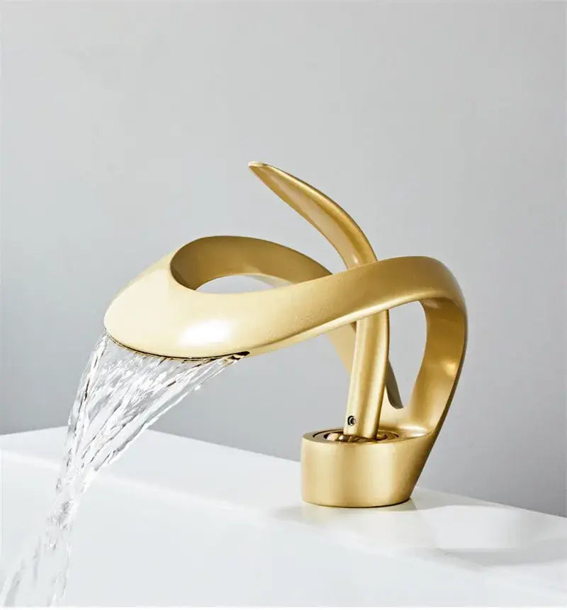 Gold-colored sleekly curved basin faucet with waterfall design made of decorbites black brass for bathroom use