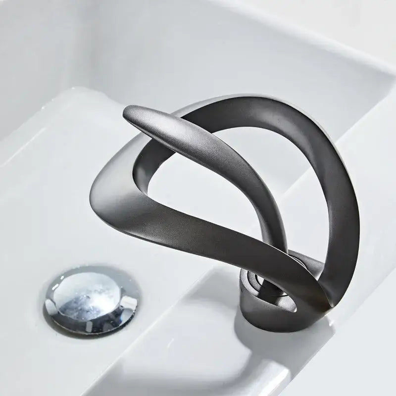 Sleek matte black brass waterfall basin faucet with flowing curves and brushed metallic finish by decorbites black brass