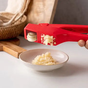 Sleek red manual garlic crusher with ergonomic design by decorbites garlic crusher for efficient kitchen grinding