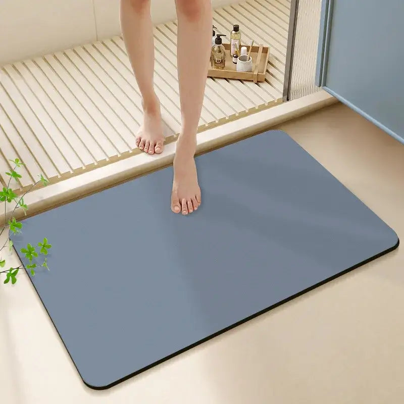Blue rectangular non-slip bath rug with black border made of diatom ooze for bathroom use