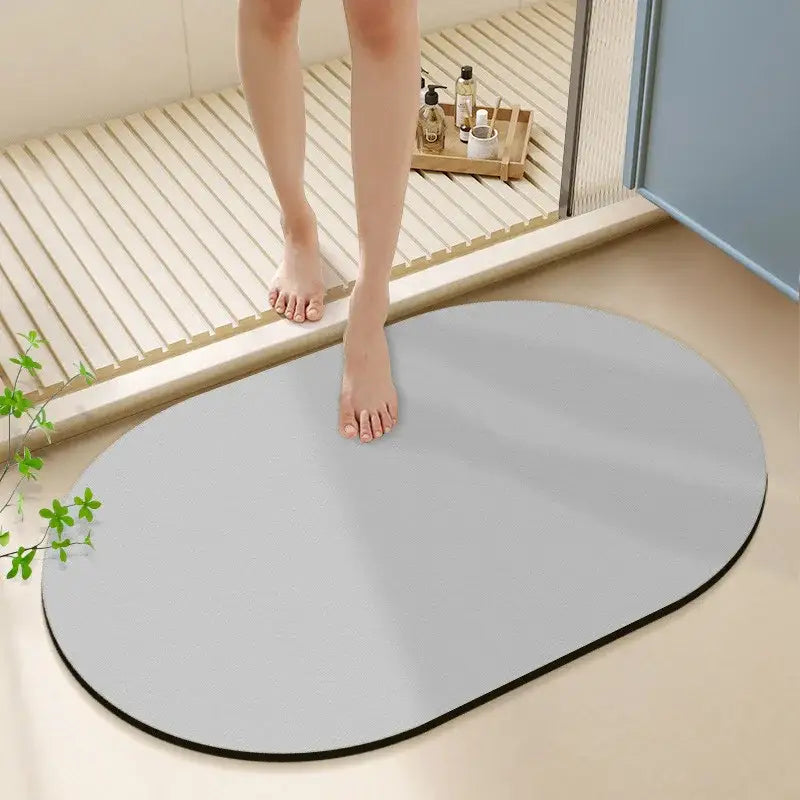 Gray oval bath rug with black border made of diatom ooze material for non-slip bathroom use