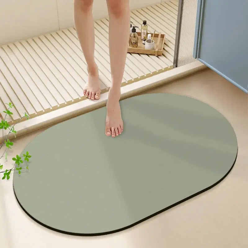 A sleek oval-shaped sage green diatom ooze bath rug with black border for bathroom non-slip bath mat