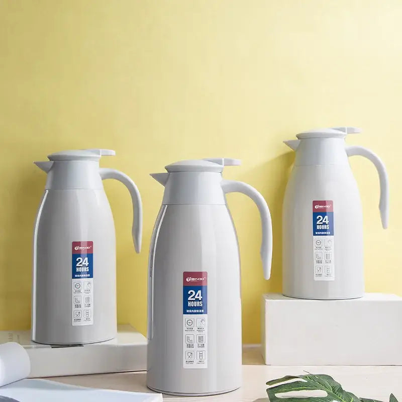 Three sleek matte white stainless steel decorbites insulavacuum bottles with curved handles and 24 hours label
