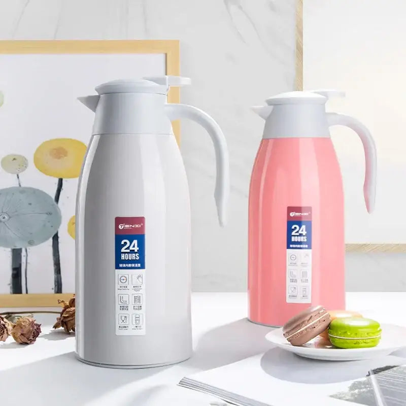 Two sleek decorbites insulavacuum bottles in matte white and soft pink stainless steel with curved handles and lids