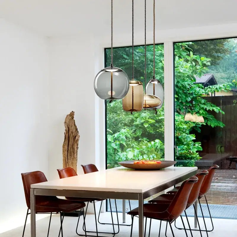Sleek smoked glass led chandelier with frosted and amber glass led pendant lights above dining table