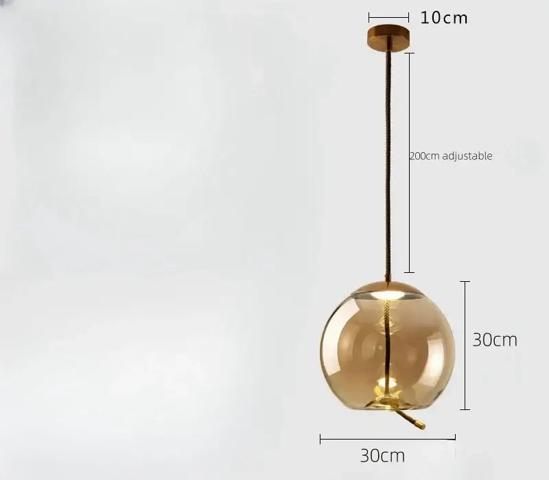 Sleek smoked glass led chandelier featuring an amber glass globe with brass fixture and adjustable black cord pendant light