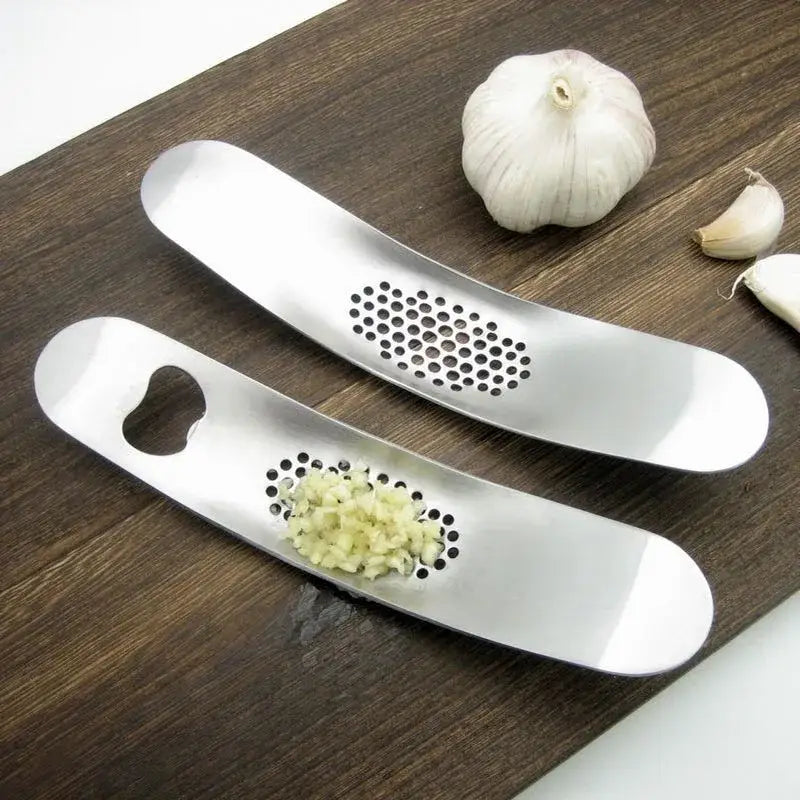 Sleek stainless steel garlic press with curved design and perforated grinding surface by decorbites garlic press