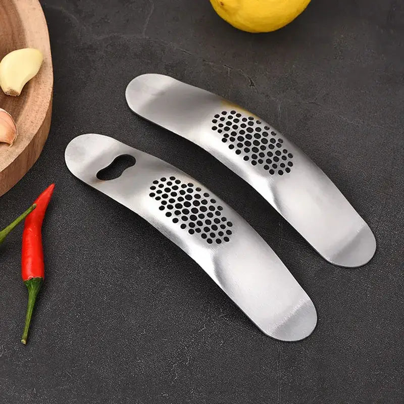 Sleek stainless steel garlic press with perforated surface and ergonomic handle by decorbites garlic press