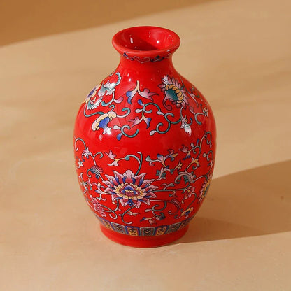 A vibrant red small ceramic vase with intricate blue pink and gold floral patterns for home and office decor