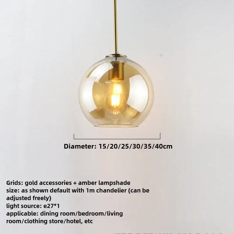 A spherical amber glass pendant light with gold-toned metal fixture and iron finish exposed light source