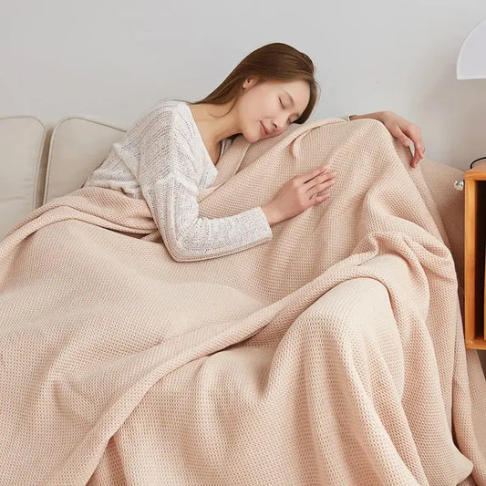 Soft beige cotton honeycomb towel blanket draped over woman sleeping on couch for living room decorbites cotton honeycomb
