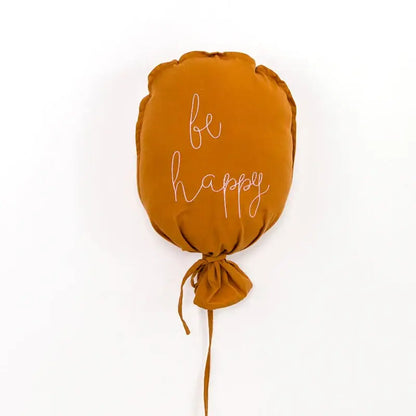 A soft cotton balloon wall hanging in mustard yellow with be happy embroidery for kids room decor