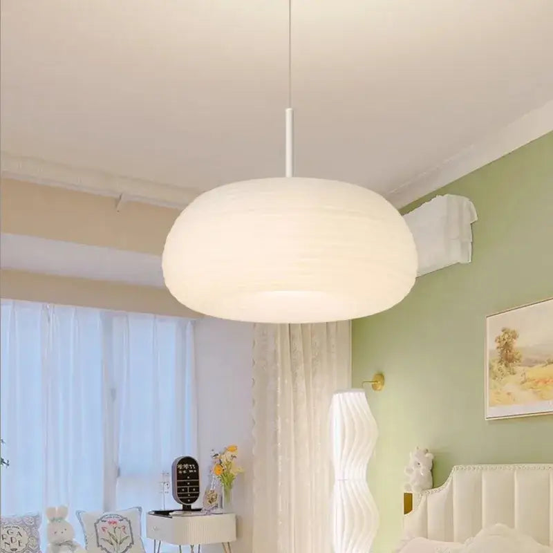 Soft cream apple paper pendant light with cloud-like shape hanging from white rod by decorbites cream apple