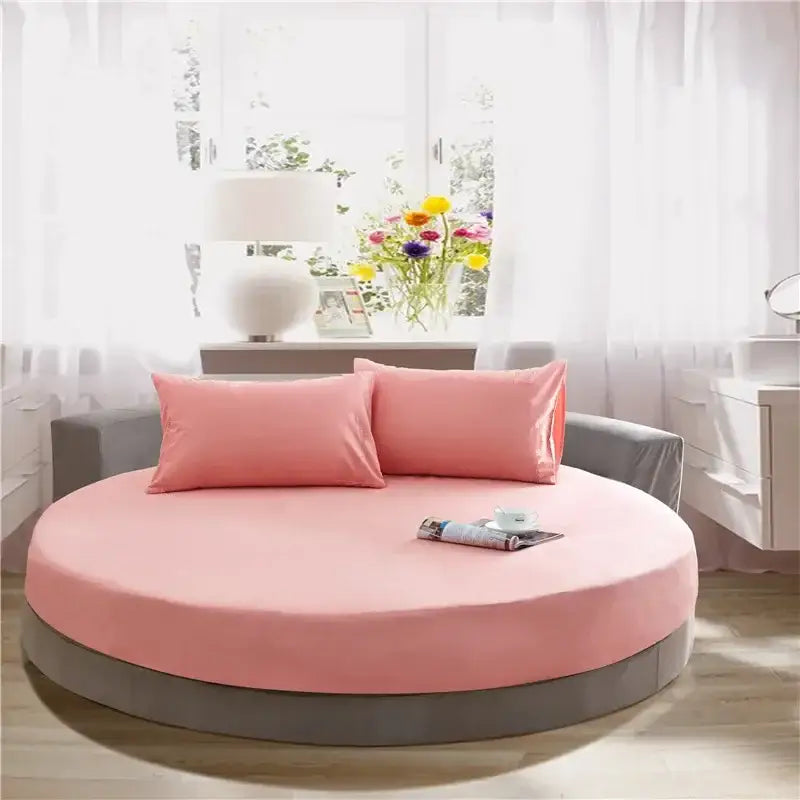 Soft dark gray cotton decorbites cotton round bed with soft pink round bed sheet and matching pillows on gray base