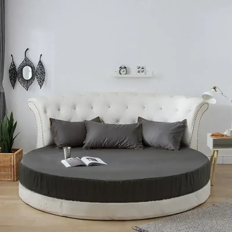 Round bed with tufted white upholstered headboard and dark gray decorbites cotton round bed sheet set in cotton round bed style