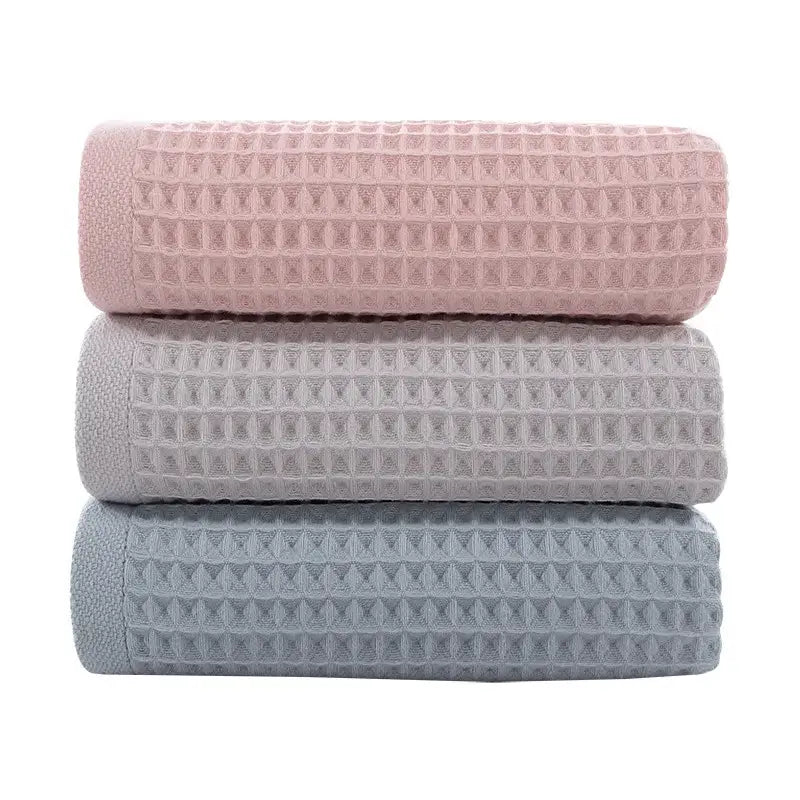Soft gray blush and blue cotton waffle towels stacked neatly showcasing decorbites cotton waffle towel bath set